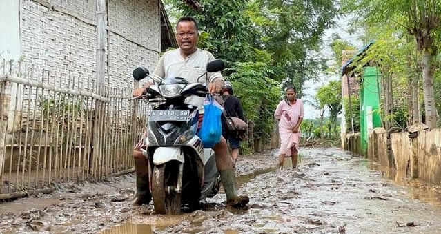 Warga saat melewati lumpur sisa banjir/RMOLJatim