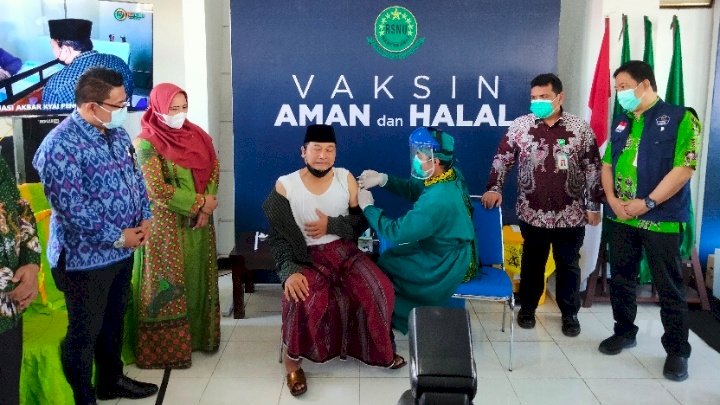 Ekspresi Ketua PCNU Banyuwangi Gus Makki menjalani vaksinasi didampingi sejumlah pejabat di RSNU dalam acara Vaksinasi Akbar/RMOLJatim