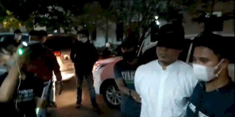 Mantan Sekretaris Umum FPI, Munarman (baju putih) dengan mata ditutup kain hitam saat tiba di Mapolda Metro Jaya/RMOL