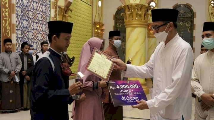 Gus Firjaun saat menyerahkan Hadiah pemenang Festival Al-Qur'an di mesjid Raudatul Mukhlisin Jember/RMOLJatim