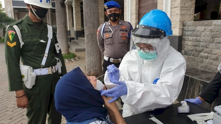 Petugas pos penyekatan di perbatasan Situbondo, memasang stiker di kendaraan pengguna jalan yang terjaring operasi/RMOLJatim