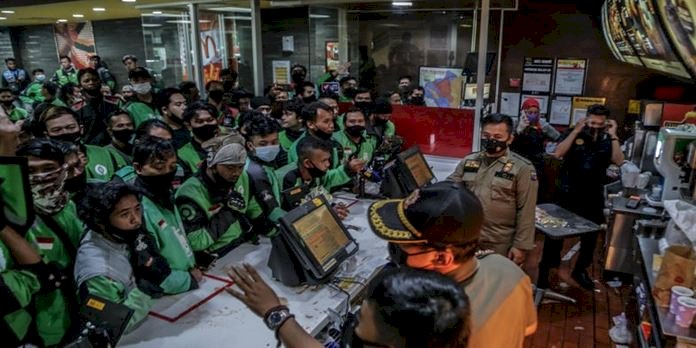 Pengemudi pengiriman makanan mengantri di gerai McDonald's di Bogor pada hari Rabu untuk membeli paket makanan BTS baru untuk penggemar lapar di negara gila K-Pop/AFP