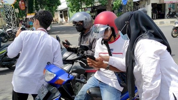 Petugas mengarahkan masyarakat daftar melalui online saat vaksin