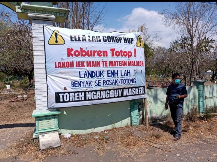 Warga melihat baliho besar di kuburan. /RMOLJatim