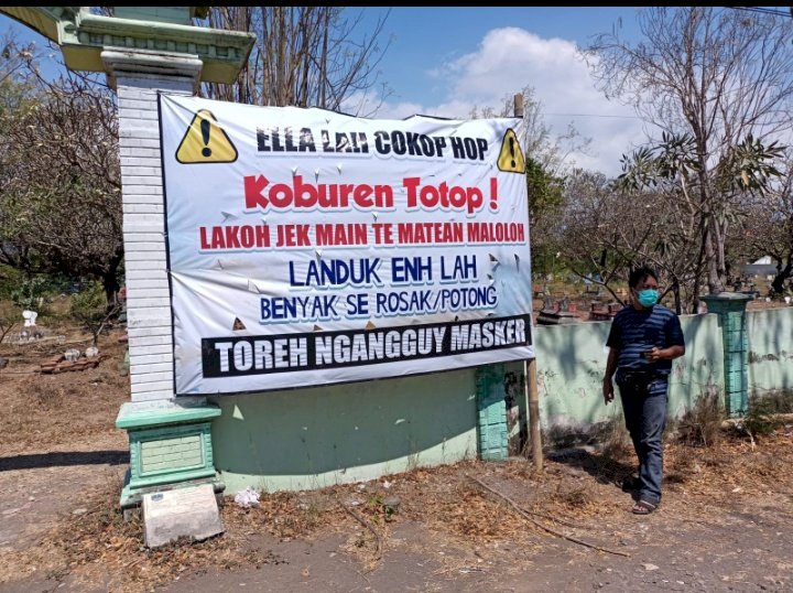 Warga melihat baliho besar di kuburan. /RMOLJatim