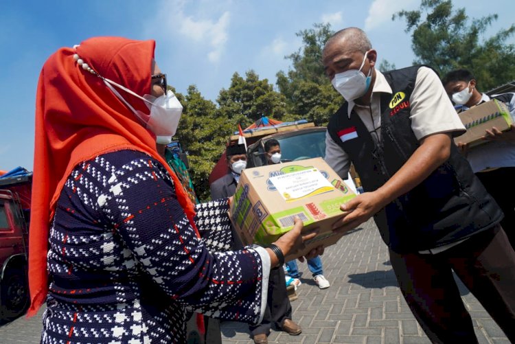 Dirut PT PON Gresik, Jaya Martapa saat memberikan bantuan paket sembako pada warga/Ist