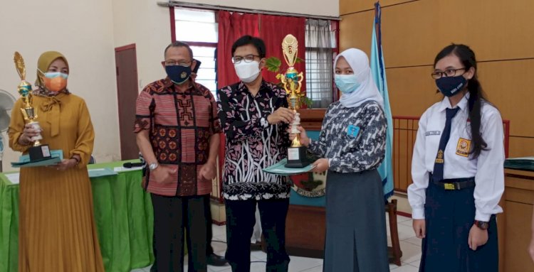 Kepala Dinas Diskoperindag Kota Malang, Muhamad Sailendra saat memberikan tropi kepada Salah Satu Juara 1 Lomba Pidato, Ganes Danastri Pratista A.A/RMOLJatim