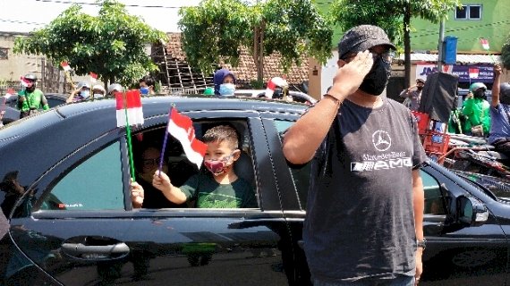 Pengendara menghormati Sang Saka Merah Putih si tengah jalan. 