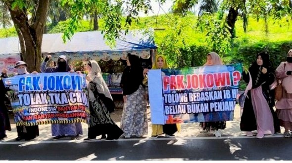 Emak-emak pencinta Habib Rizieq Shihab membentangkan banner menyampaikan aspirasi atau pesan saat rombongan Presiden Joko Widodo sampai di Natar, Lampung Selatan/Ist
