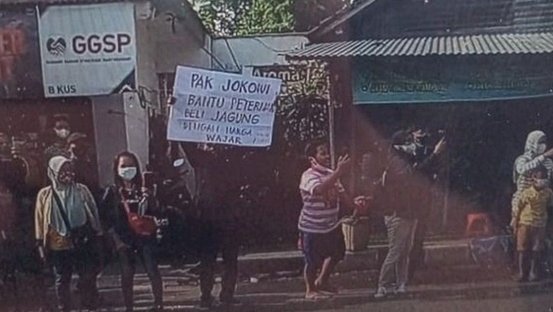 Peternak ayam di Blitar membentangkan poster soal harga jagung saat Presiden Joko Widodo kunjungan kerja/Net