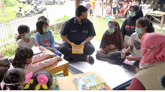 Menteri Badan Usaha Milik Negara (BUMN), Erick Thohir saat membacakan buku cerita bergambar tentang pentingnya protokol kesehatan kepada anak-anak di Taman Bacaan Masyarakat (TBM) Cikuya, Kabupaten Tangerang/Ist