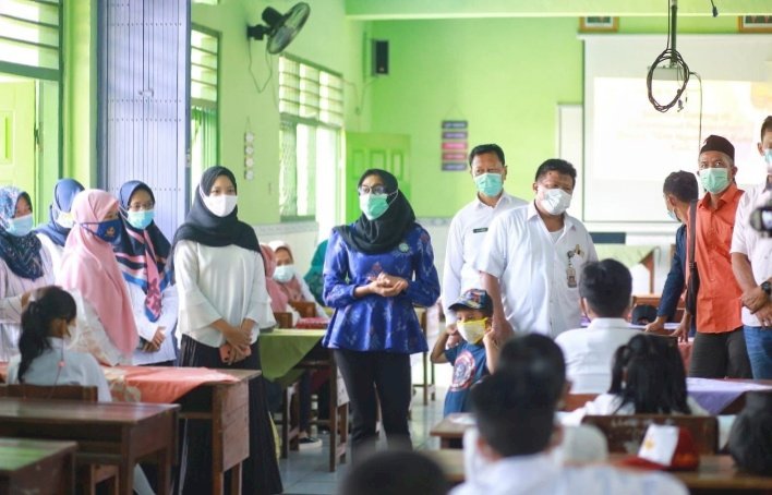 Penyerahan bantuan buku kepada wali murid/net