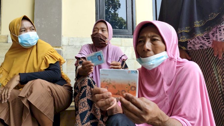 Seorang penerima PKH menunjukkan buku tabungan Banknya di halaman Mapolres Probolinggo/RMOLJatim