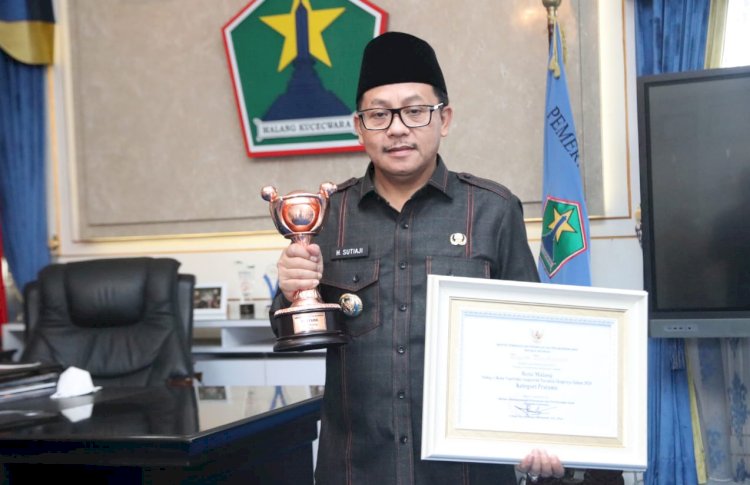 Wali Kota Malang, Drs. H. Sutiaji saat memegang Trophy penghargaan/Ist