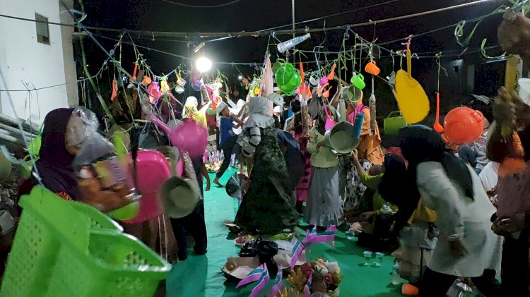 Warga saat merebutkan perabotan rumah tangga di halaman Musolla Azzahra /RMOLJatim