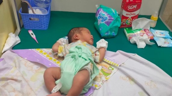 Bayi laki laki yang diletakkan  di dalam kardus/ist