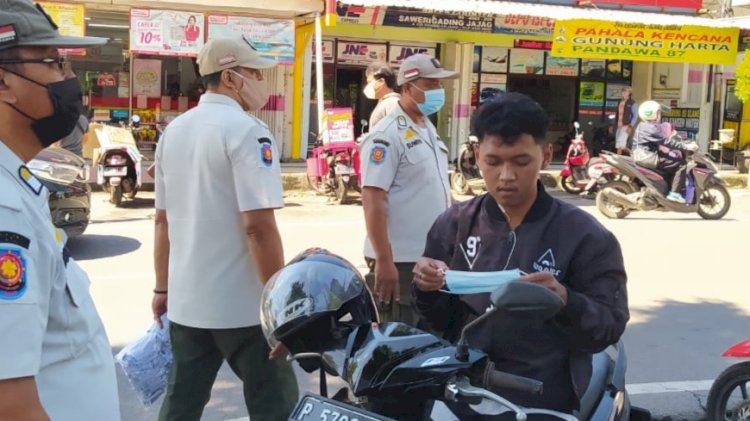 Seorang pengendara terjaring operasi yustisi di wilayah Kecamatan Gambiran dan diberi masker oleh petugas/RMOLJatim