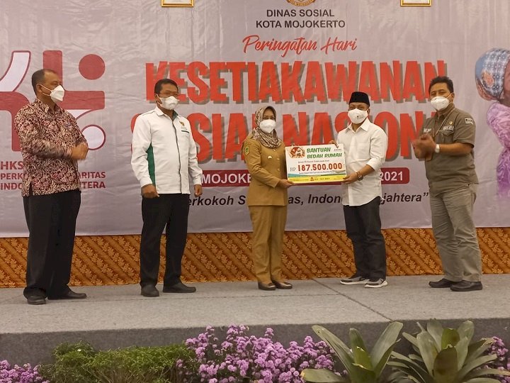 Wakil Ketua III, Baznas Jatim, Moh. Zaki secara simbolis menyerahkan bantuan bedah rumah untuk warga dhuafa Kota Mojokerto kepada Wali Kota Mojokerto, Ika Puspitasari/ist