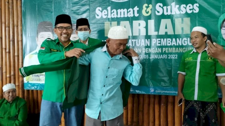 Fungsionaris PPP Kabupaten Probolinggo, Mahdi saat memasangkan jaket PPP pada Pelawak Sukur. /RMOLJatim