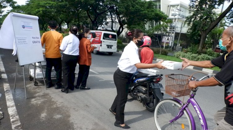 The Irsan Pribadi membagikan nasi kotak pada pengguna jalan/Ist