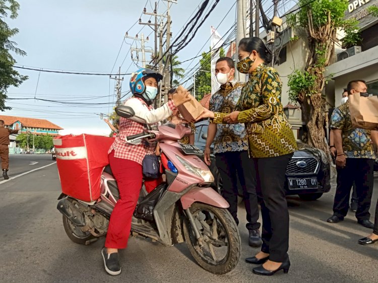 Kajari Tanjung Perak I Ketut Kasna Dedi mendampingi Ketua IAD Eka Kasna saat membagikan takjil ke Krisdayanti, pedagang minuman kesehatan/RMOLJatim