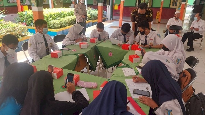 Kasi Intelijen Kejari Tanjung Perak Putu Arya Wibisana bersama Siswa-Siswi SMPN 2 Surabaya saat diskusi menjawab pertanyaan game yang berikan tim Jaksa Masuk Sekolah (JMS)/RMOLJatim