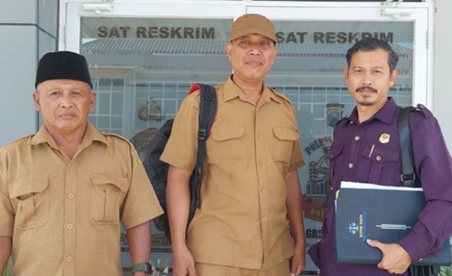 Kades Tebalo Ahmad Mahsul (tengah) bersama staf dan kuasa hukumya usai menjalani pemeriksaan di Polres Gresik/RMOLJatim