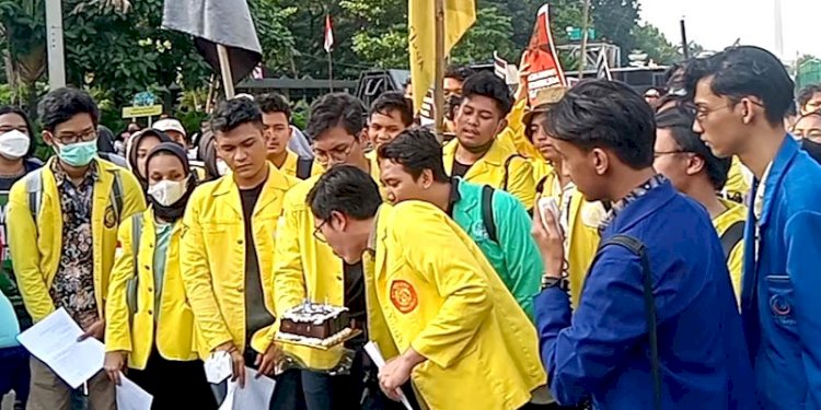 Para mahasiswa yang berunjuk rasa meniup lilin kue ulang tahun bagi Presiden Jokowi di tengah aksi unjuk rasa/RMOL