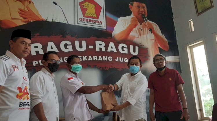 Sutadi saat menyerahkan daging kurban kepada warga/RMOLJatim