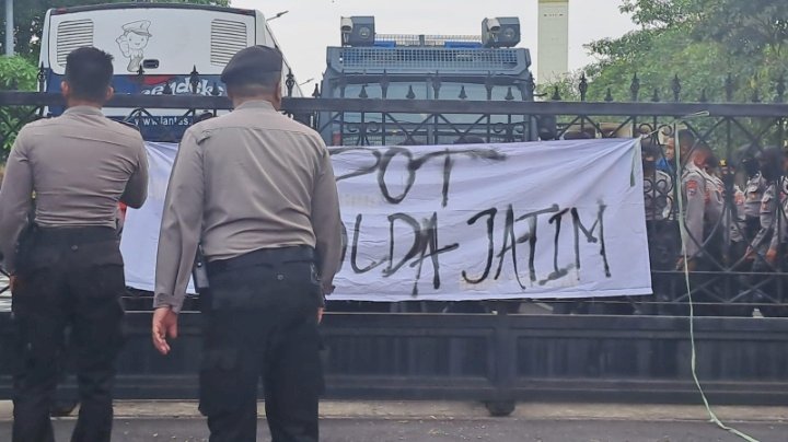 Spanduk bertuliskan "Copot Kapolda Jatim" ditempel di gerbang Mapolda Jatim. 