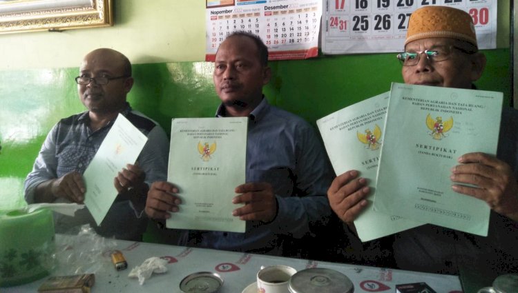 Ketua Program PTSL Desa Tembeling Kecamatan Kasiman Bojoneogoro Ahmad Nur Khotim (tengah) didampingi kuasa hukumnya/RMOLJatim