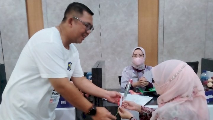 Kajari Tanjung Perak Aji Kalbu Pribadi saat membagikan bunga ke pengunjung Mall Pelayanan Publik Siola/RMOLJatim