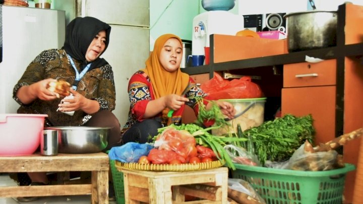 Teks foto: Zulfa Rahmanita Rosidah bekerja di dapur permakanan Dinsos Surabaya/ist