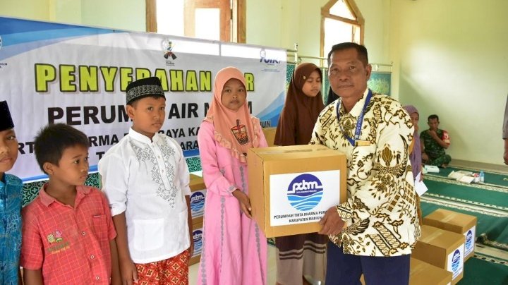 Keterangan foto: Direktur Perumda Air Minum (PDAM) Tirta Dharma Purabaya Kabupaten Madiun Sumariyono memberikan paket bantuan dan santunan/ist.