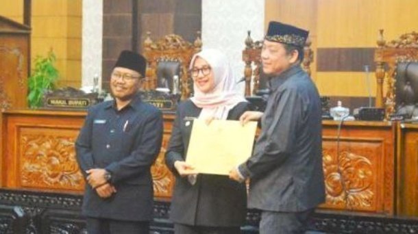 Caption: Bupati Ipuk didampingi Wabup Sugirah memberikan dokumen nota pengantar Raperda usulan eksekutif kepada Pimpinan DPRD, Michael Edy Hariyanto/RMOLJatim