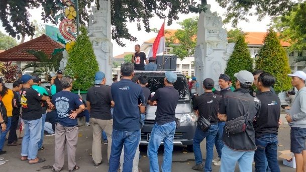 Caption: Aksi saling dorong driver online versus polisi warnai Festival Sewu Driver di Kantor Bupati Banyuwangi/RMOLJatim