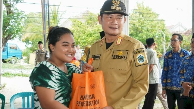 Caption : Bupati  Lamongan Yuhronur Efendi  saat menyalurkan  paket sembako di Glagah Lamongan 
