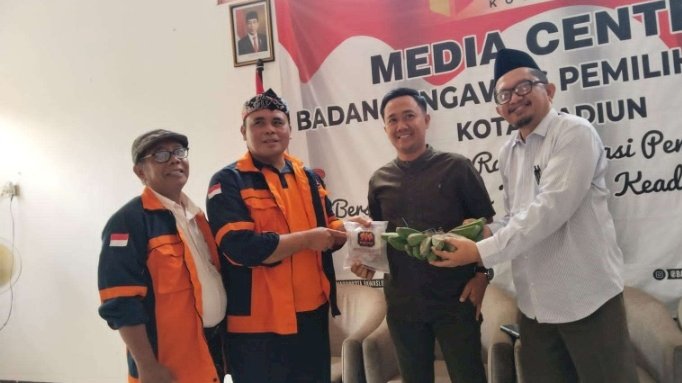 Keterangan foto : Ketua LSM WKR Budi Santoso secara simbolis memberikan hadiah pisang mentah dan karbit kepada komisioner Bawaslu kota Madiun/ist.