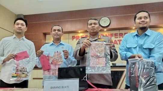 polisi menunjukkan barang bukti 