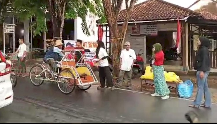 Pengurus PSI Sumenep saat membagikan nasi kotak kepada Abang becak/Ist