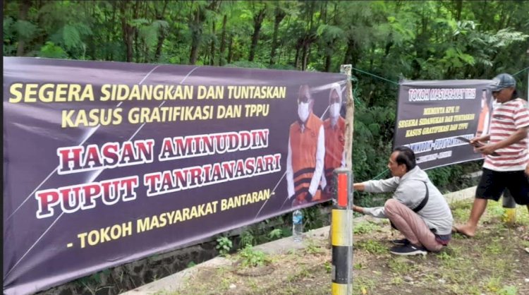 Warga saat memasang banner dukungan terhadap KPK untuk mengusut tuntas kasus TPPU Hasan Aminuddin dan Puput Tantriana Sari. /RMOLJatim