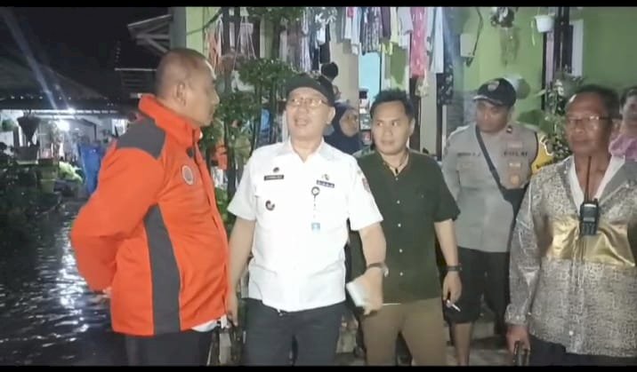  Foto; Widodo Julianto, Kepala BPBD Jember, (jaket oranye) saat meninjau lokasi banjir genangan di Kecamatan Kaliwates.