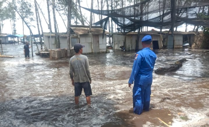 Anggota Satpolairud Puger Polres Jember saat membantu warga terdampak banjir rob/Ist