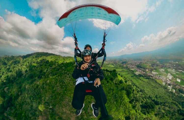 Bupati Banyuwangi Ipuk Fiestiandani memamerkan keindahan pemandangan saat mencoba paralayang dari Gunung Menyan Kalibaru/Humas Pemkab Bwi