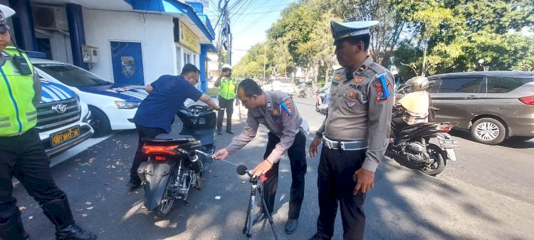 Teks: Kanit Turjawali Satlantas Polres Gresik Ipda Bross Tito Dharmawan melakukan cek alat kebisingan knalpot brong