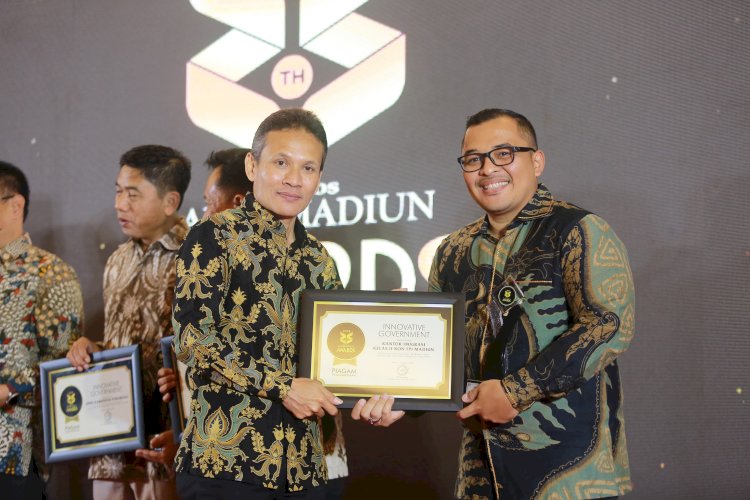 Kepala Kantor Imigrasi kelas II Non TPI Madiun Gilang Danurdara (kanan) saat menerima penghargaan dari Direktur Jawa Pos Radar Madiun Marsudi Nurwahid/Dokumen Imigrasi Madiun. 