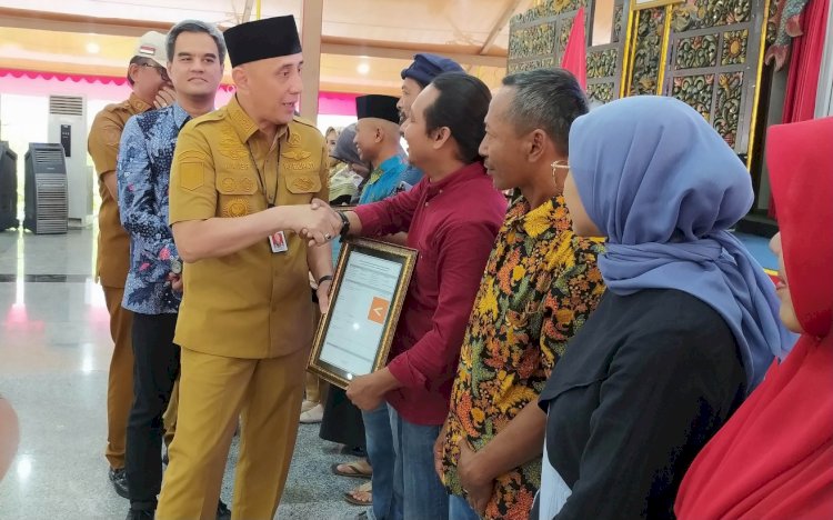 Pj Bupati Bangkalan, Arief Moelya Edie, menyerahkan sertifikat halal kepada pelaku IKM/RMOLJatim