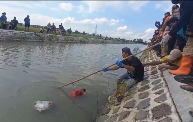 Proses evakuasi jasad bayi dalam kantong plastik mengapung di aliran sungai Sono Madiun/RMOLJatim
