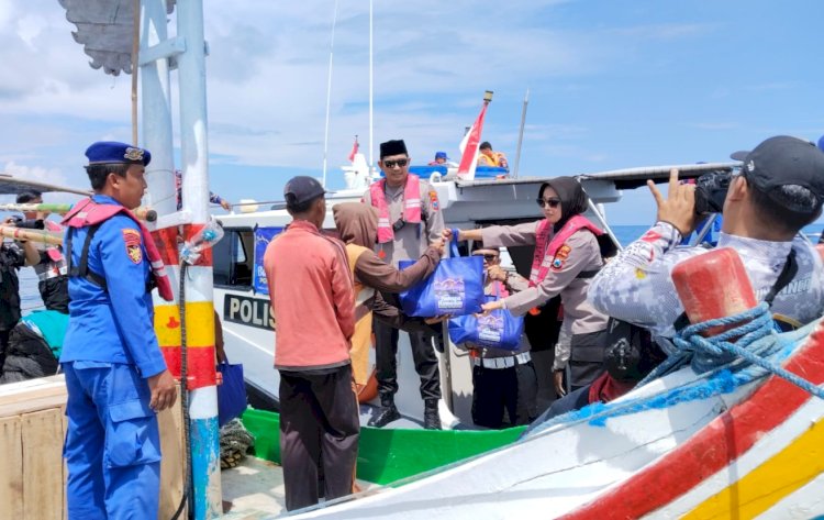 Kapolres Situbondo AKBP Rezi Dharmawan saat membagikan sembako kepada nelayan yang lagi mencari ikan di tengah laut/RMOLJatim