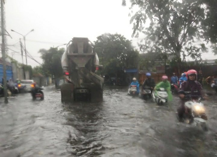 Teks foto: Air dari kali Kandangan meluap hingga ke jalan raya/RMOLJatim